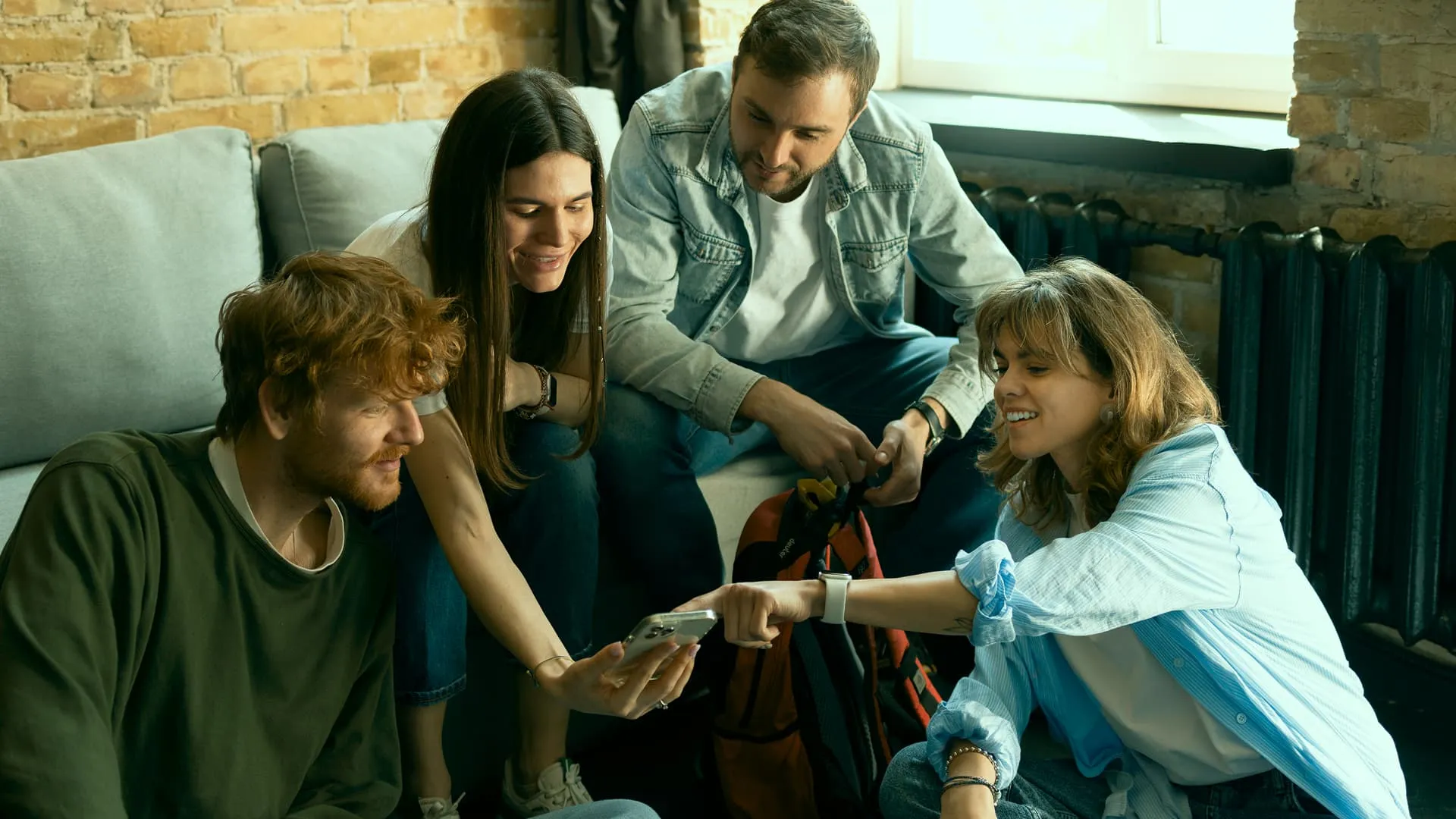 Group of people drinking coffee, smiling, and holding mobile phone.